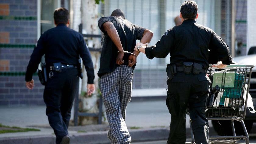 LAPD officers arrest a man on skid row for possession of a stolen shopping cart in 2016.