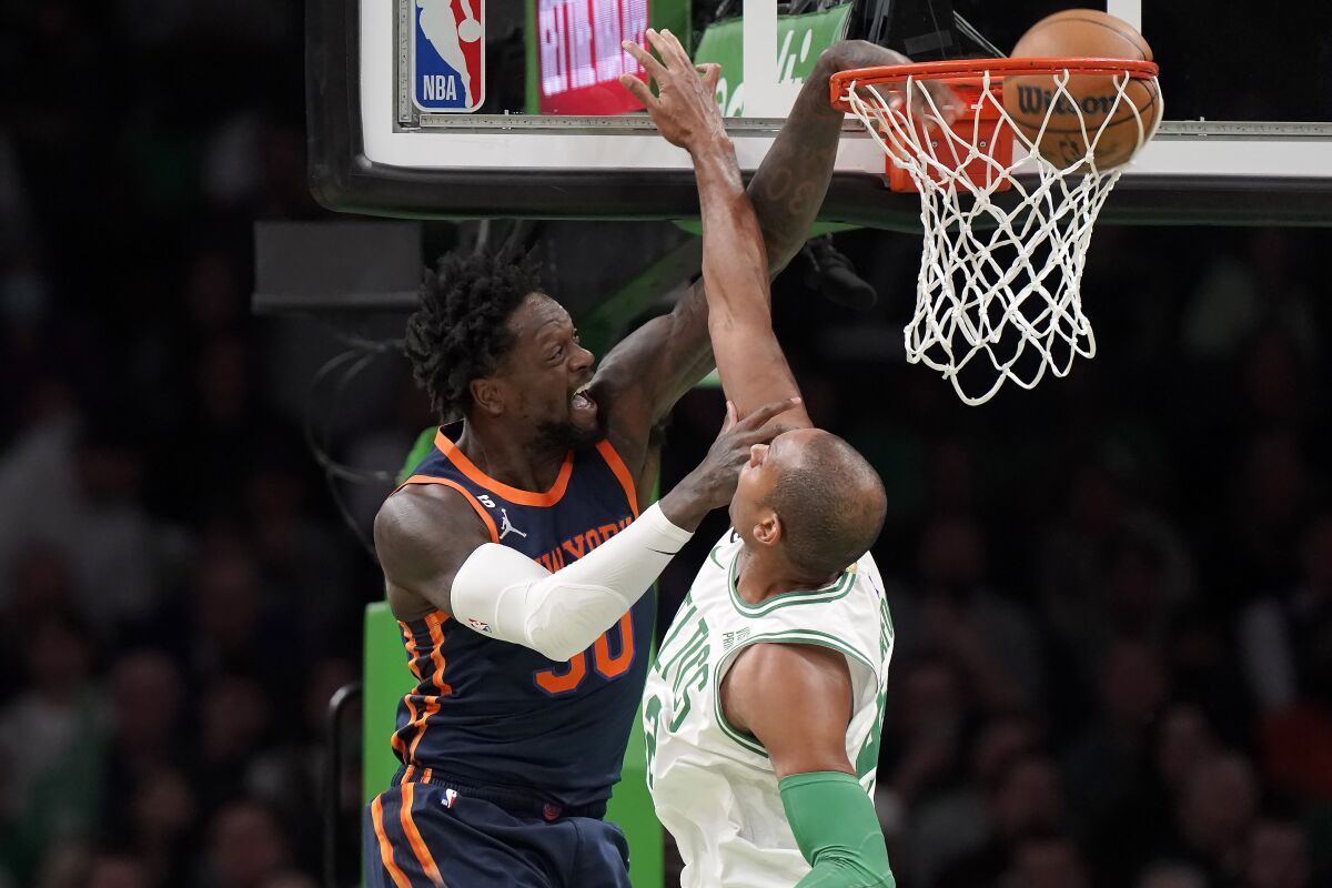 New York Knicks forward Julius Randle (30) drives to the basket to score as Boston Celtics center Al Horford, right, defends during the first half of an NBA basketball game Thursday, Jan. 26, 2023, in Boston. (AP Photo/Steven Senne)