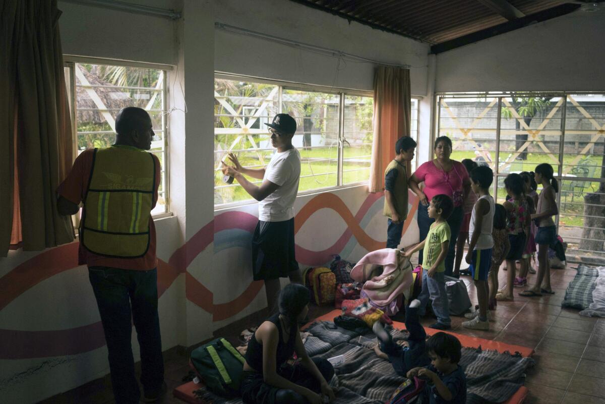 As people begin to arrive, men try to secure the windows at a makeshift shelter from Hurricane Patricia, in the Pacific resort city Puerto Vallarta, Mexico.