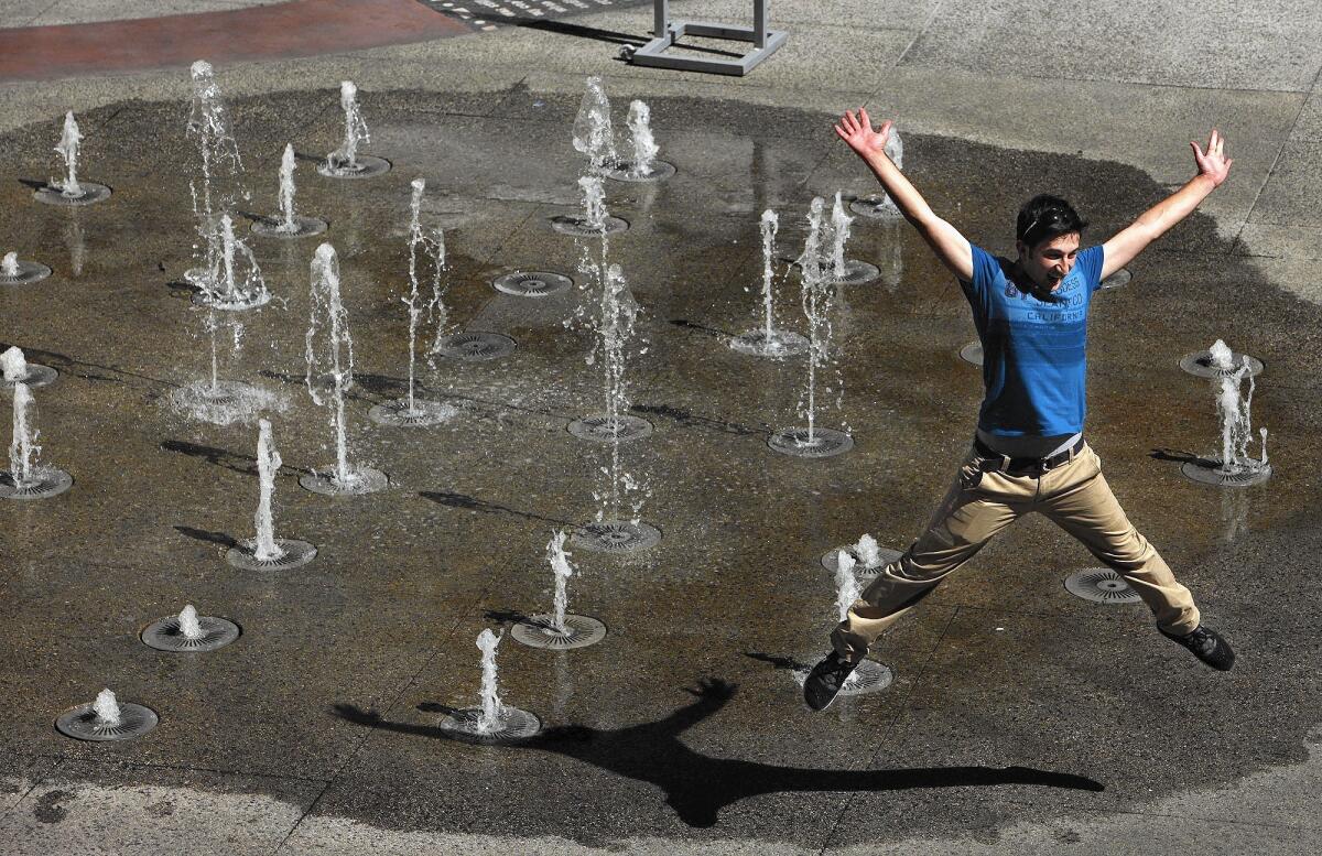 Necmettin Tekin, an exchange student from Turkey, cools off in a fountain at the Hollywood & Highland complex earlier this month.