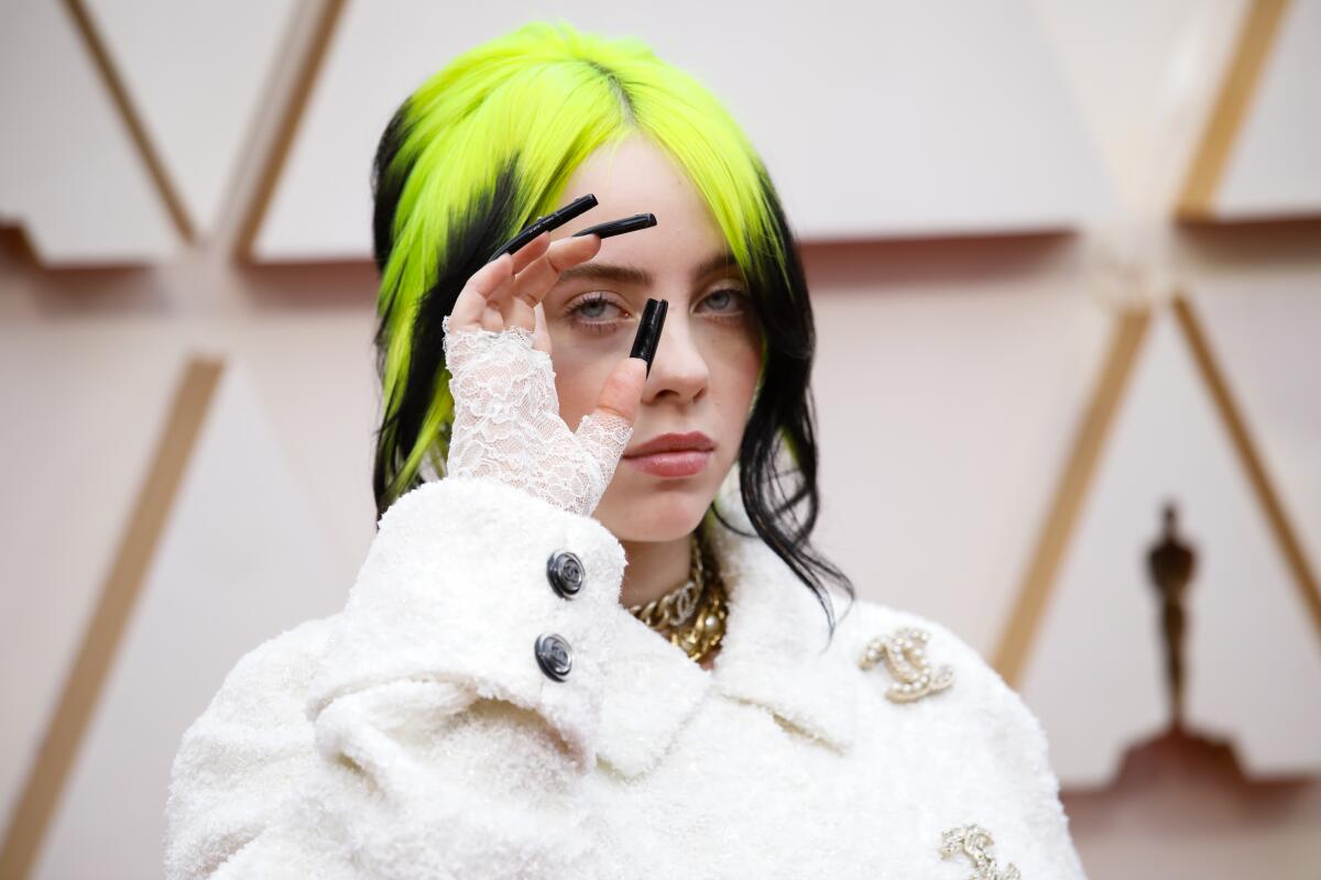 Picking up where the Grammys left off last month, Billie Eilish shows off her long nails and neon and black hair at the 92nd Academy Awards.
