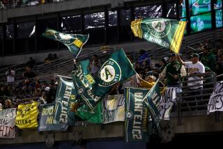 Fans wave flags during the Oakland Athletics game against the Texas Rangers at the Oakland Coliseum on September 24