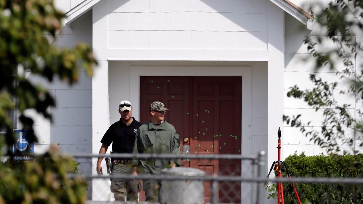 Law enforcement officials walk past the front doors of the First Baptist Church in Sutherland Springs, Texas.