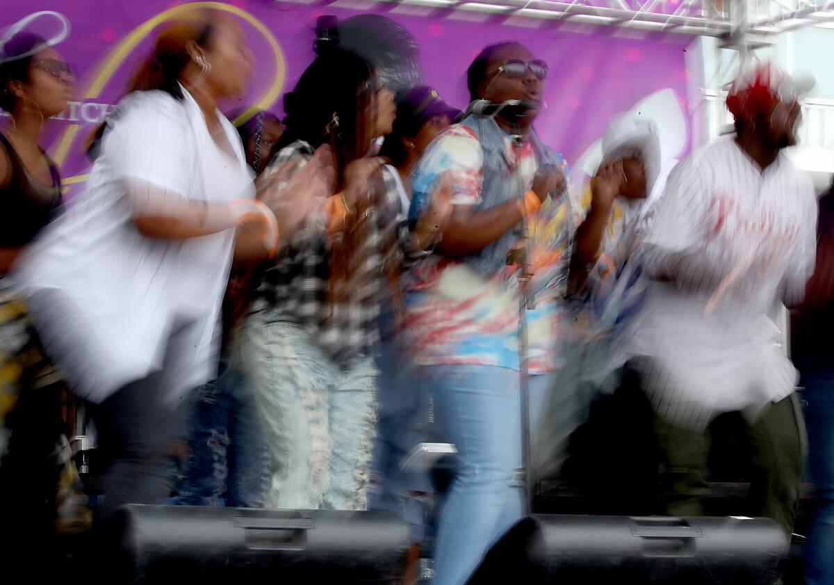 A blurred photo of a choir singing into a microphone on stage.