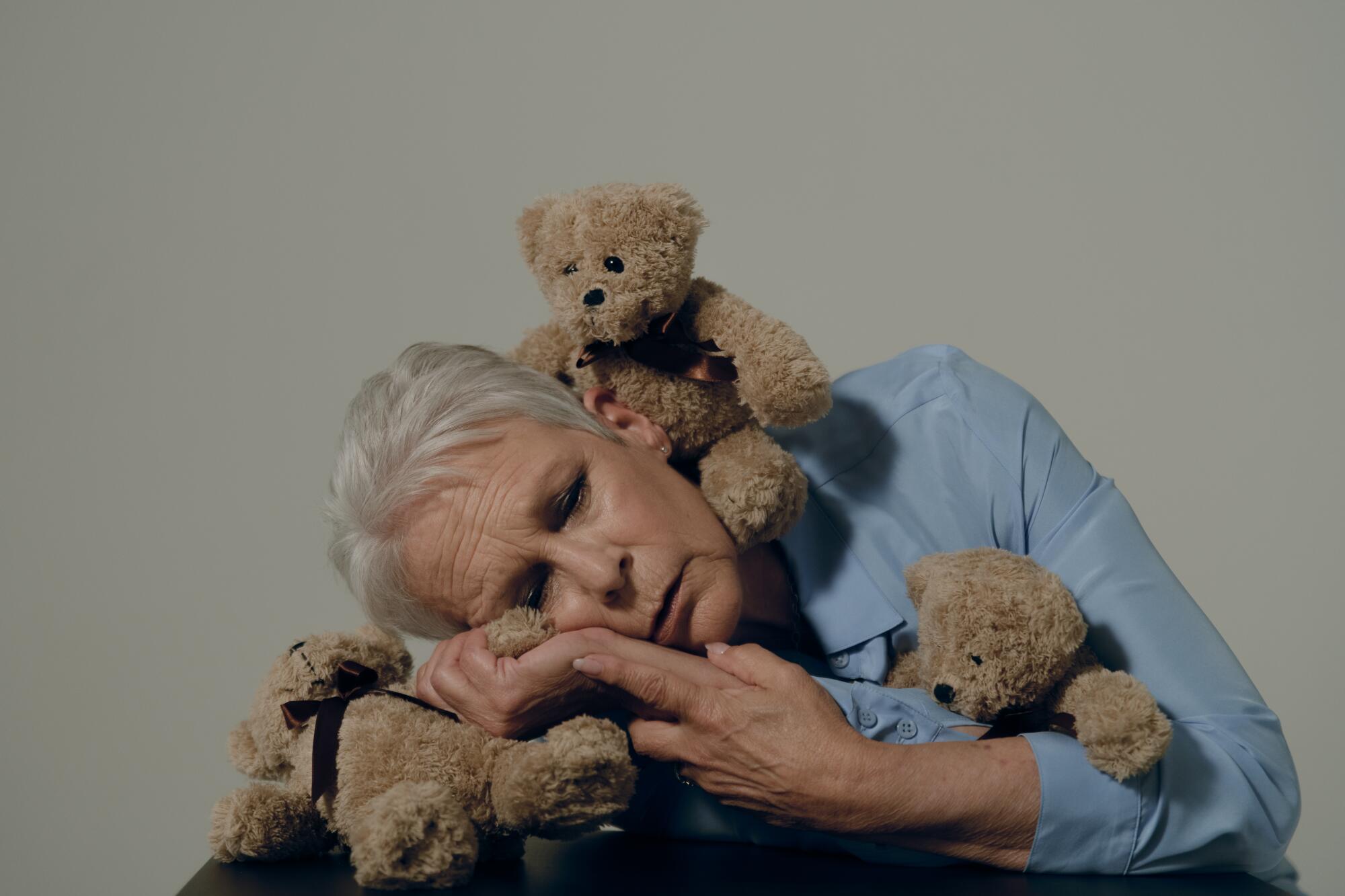 Jamie Lee Curtis snuggles with three small stuffed bears.