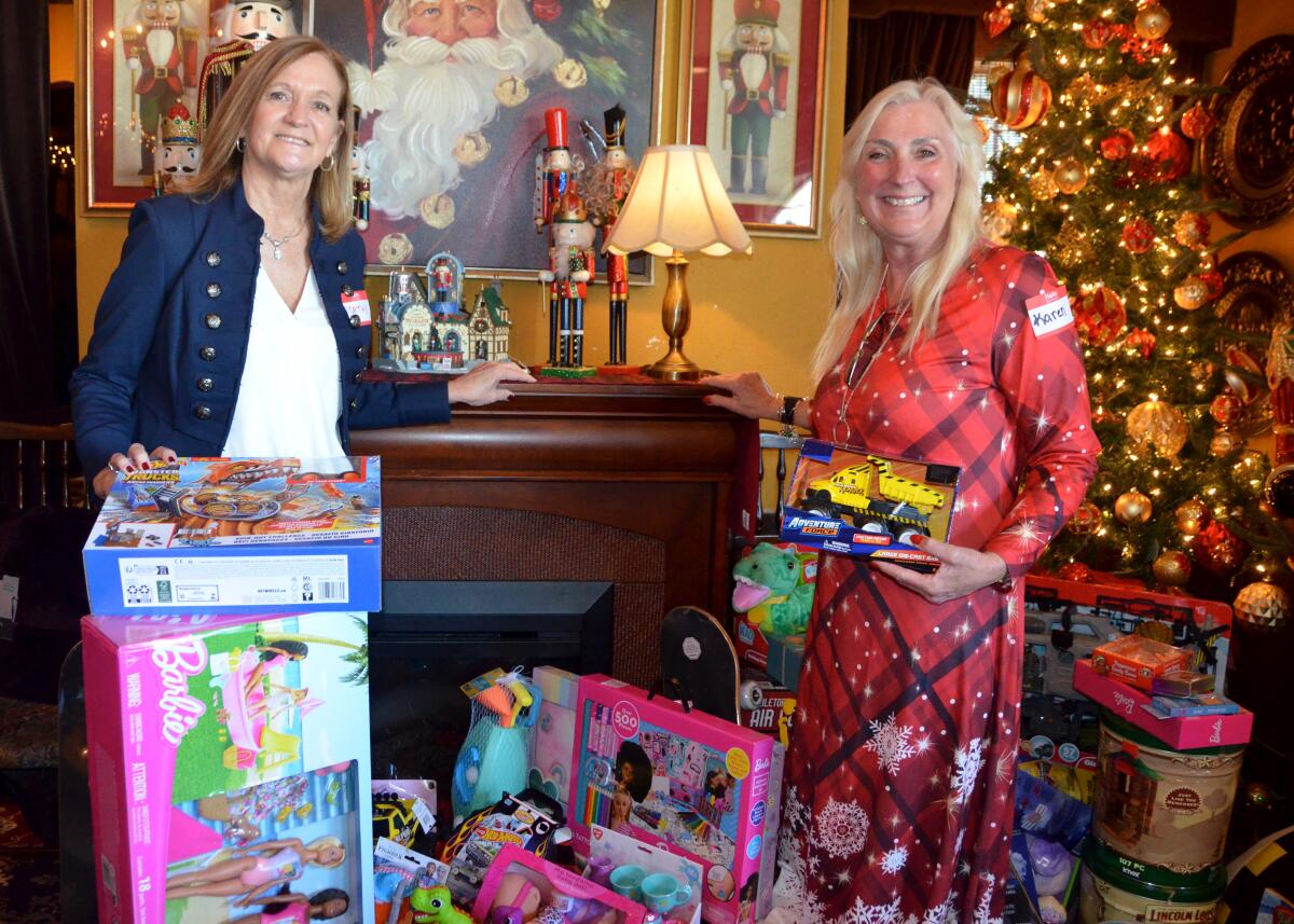 Cathy Jensen, left, and organization secretary Karen Wilson stand with the toys for Marine families.