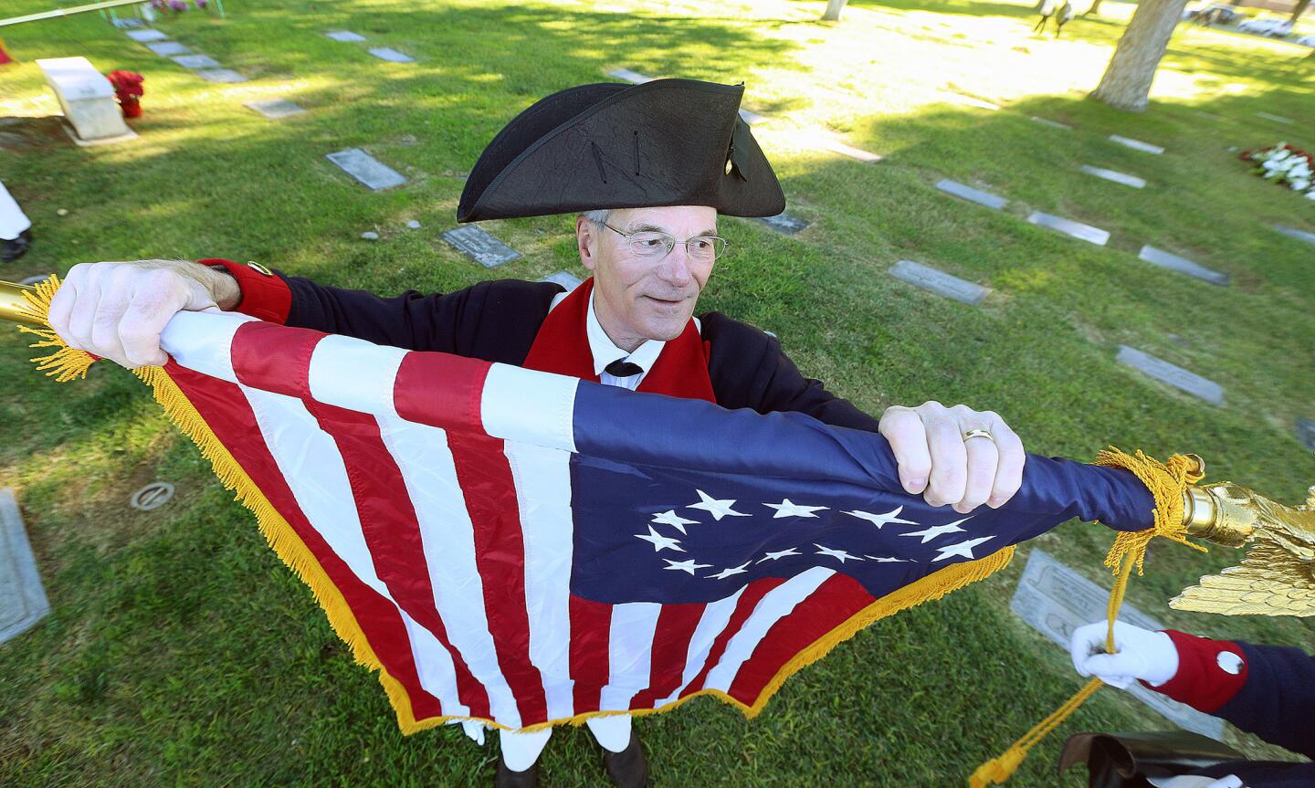 Jim Klingler, a member of the Orange County chapters of Sons of the American Revolution, rolls up a 13-star Betsy Ross Flag at a ceremony to commemorate Wreaths Across America Day at Memory Garden Memorial Park in Brea on Dec. 15. With assistance from veterans, junior ROTC programs and wreath sponsors representing military eras spanning from the American Revolution to today, more than 3,500 wreaths were placed on markers in the cemetery, starting in the Veterans' Field of Honor. Brea is one of nearly 1,000 locations where Wreaths Across America Day is commemorated.