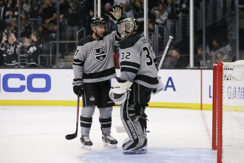 Los Angeles Kings defenseman Alec Martinez, left, congratulates goaltender Jonathan Quick after the Kings defeated the Calgary Flames 4-1 in an NHL hockey game in Los Angeles, Saturday, Oct. 19, 2019. (AP Photo/Alex Gallardo)