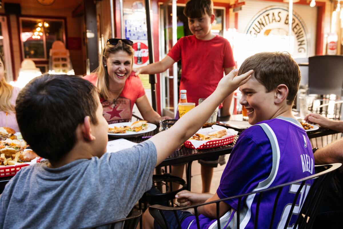 Boys tease each other at dinner table with family