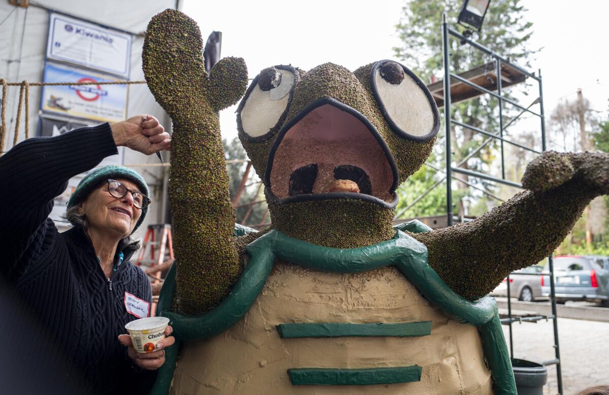 Judy Schwarz decorates a turtle on a Rose Parade float