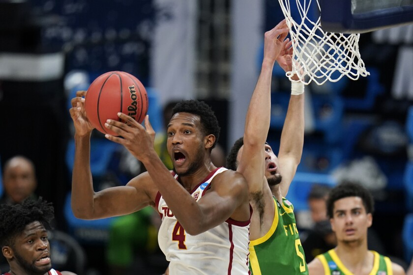 USC forward Evan Mobley grabs a rebound in front of Oregon guard Chris Duarte.