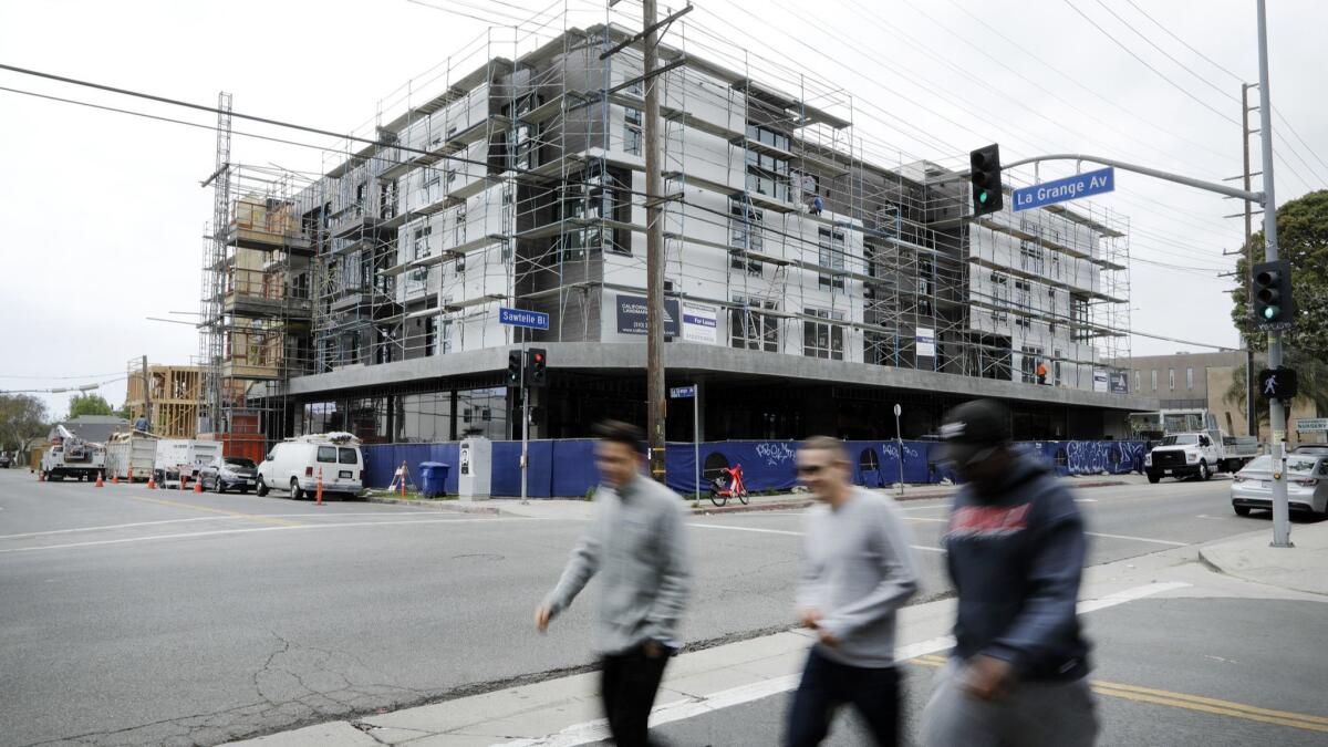 A state order will force cities in Southern California to plan for more and denser housing, such as this apartment complex under construction on Sawtelle Boulevard in Los Angeles in May.