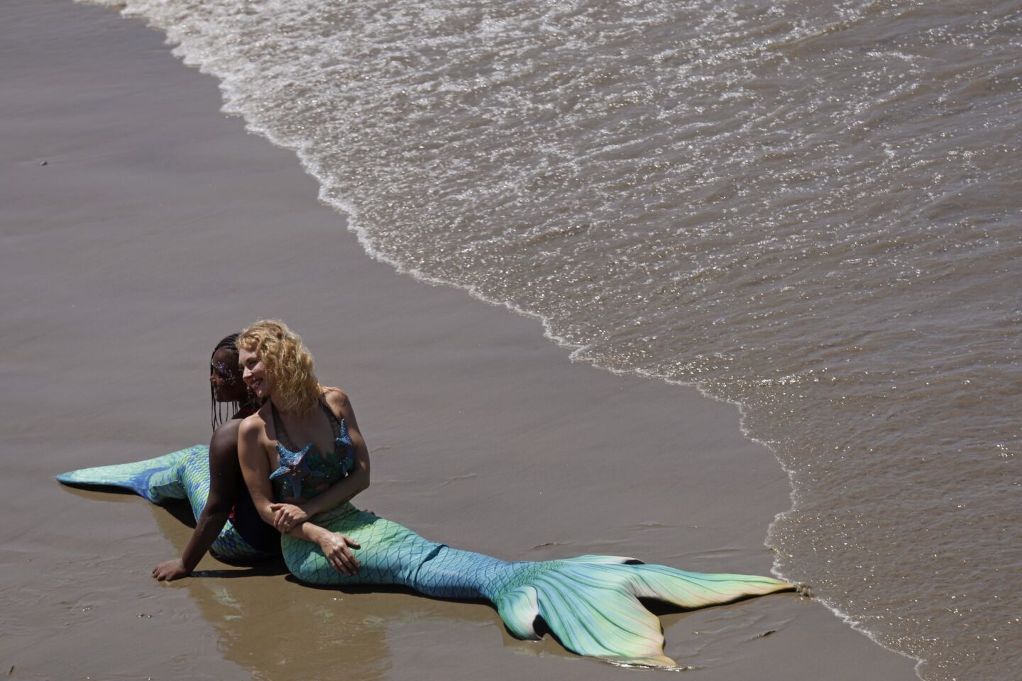 Promise Edmondson, 10, left, of Indianapolis and actress Megan Mills are just a pair of mermaids who don't seem to mind the heat in Santa Monica. Promise was fulfilling a birthday wish to be a mermaid for a day.