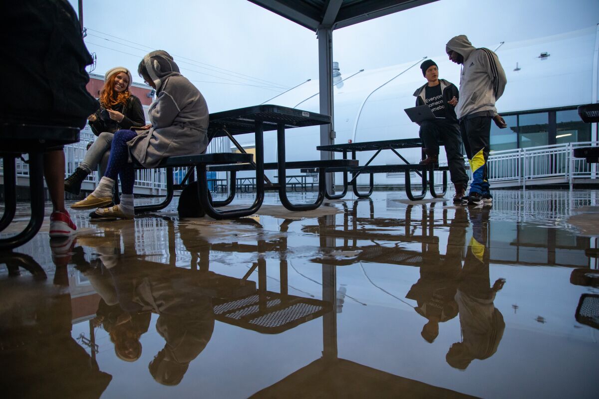 John Ma, right, seated, signs up Johnny Brock, a Bridge shelter resident, for the Miracle Messages program.