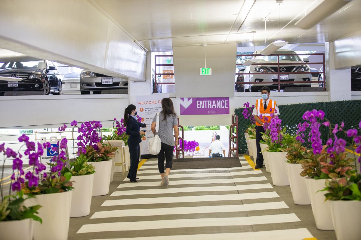 A guest is met by an attendant upon arriving at the Pavilion at South Coast Plaza in Costa Mesa on Friday.