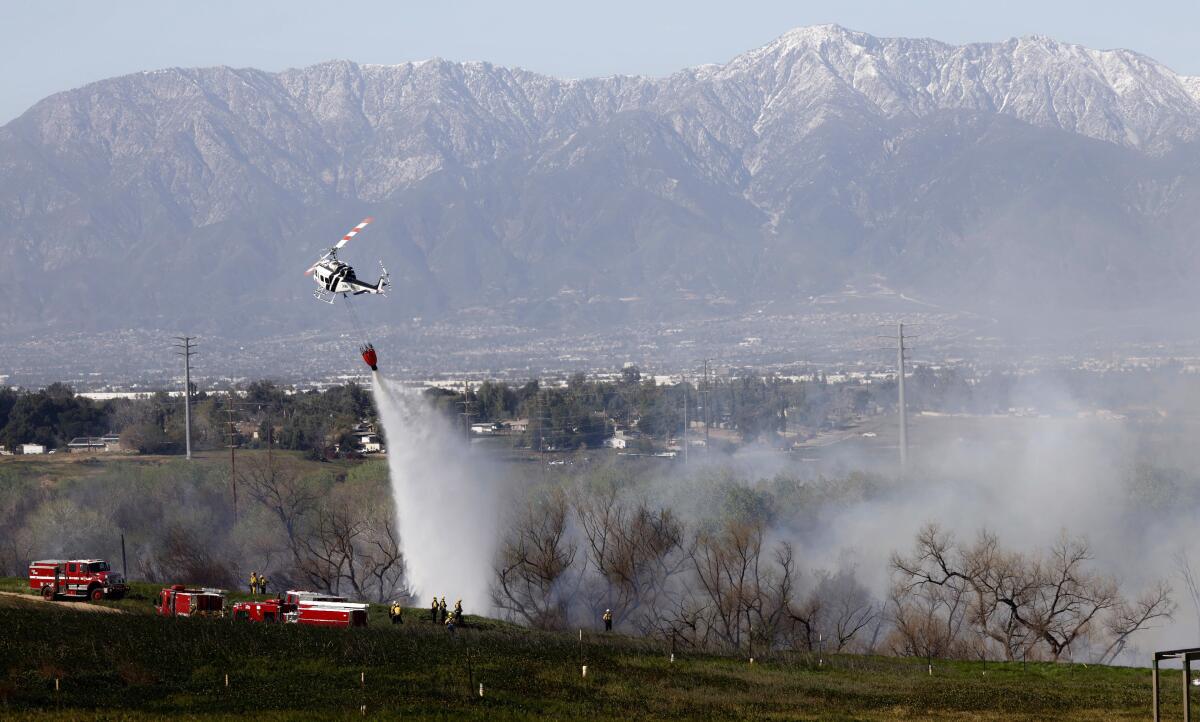 Fire crews get a handle on a brush fire, dubbed the Mann fire, that broke out in Norco on Tuesday,