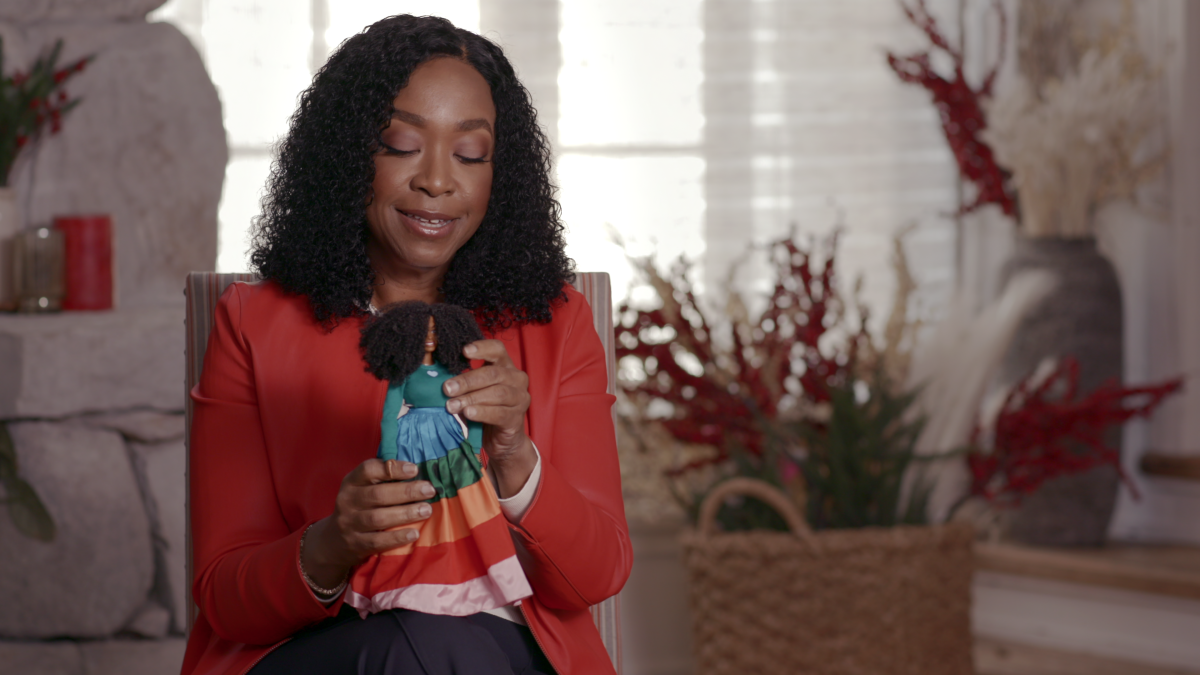 TV producer Shonda Rhimes looks at the Barbie based on her image in a scene from the new Netflix documentary "Black Barbie."