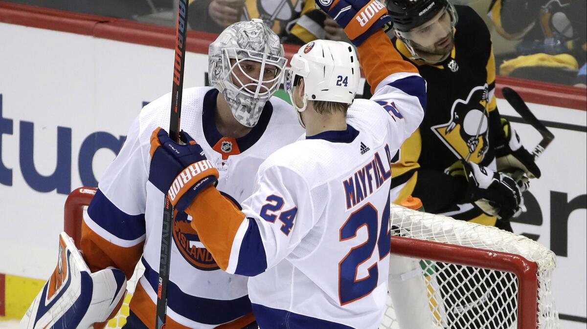 New York Islanders goaltender Robin Lehner, left, celebrates with teammate Scott Mayfield during Sunday's 4-1 victory over the Pittsburgh Penguins.