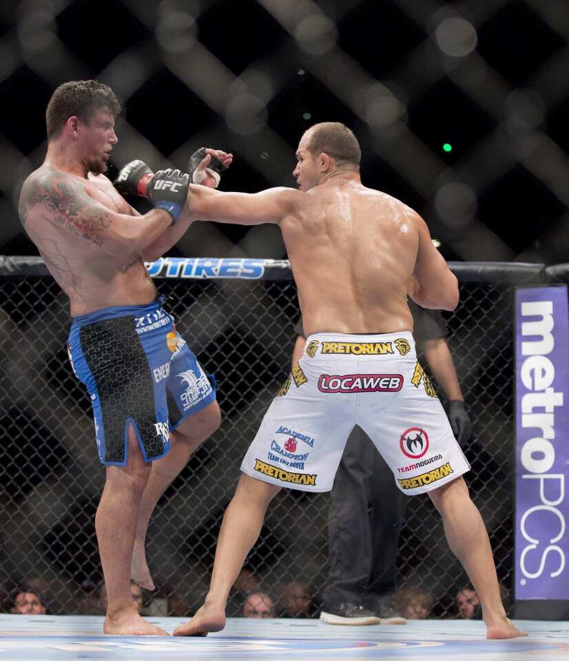 Junior Dos Santos sends Frank Mir reeling with a punch to his head in the second round of their UFC heavyweight championship fight on Saturday night in Las Vegas.