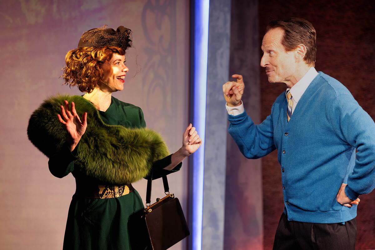 Ann Noble, in a green dress and fur, and Leo Marks, in a blue cardigan, in the play "Crevasse."