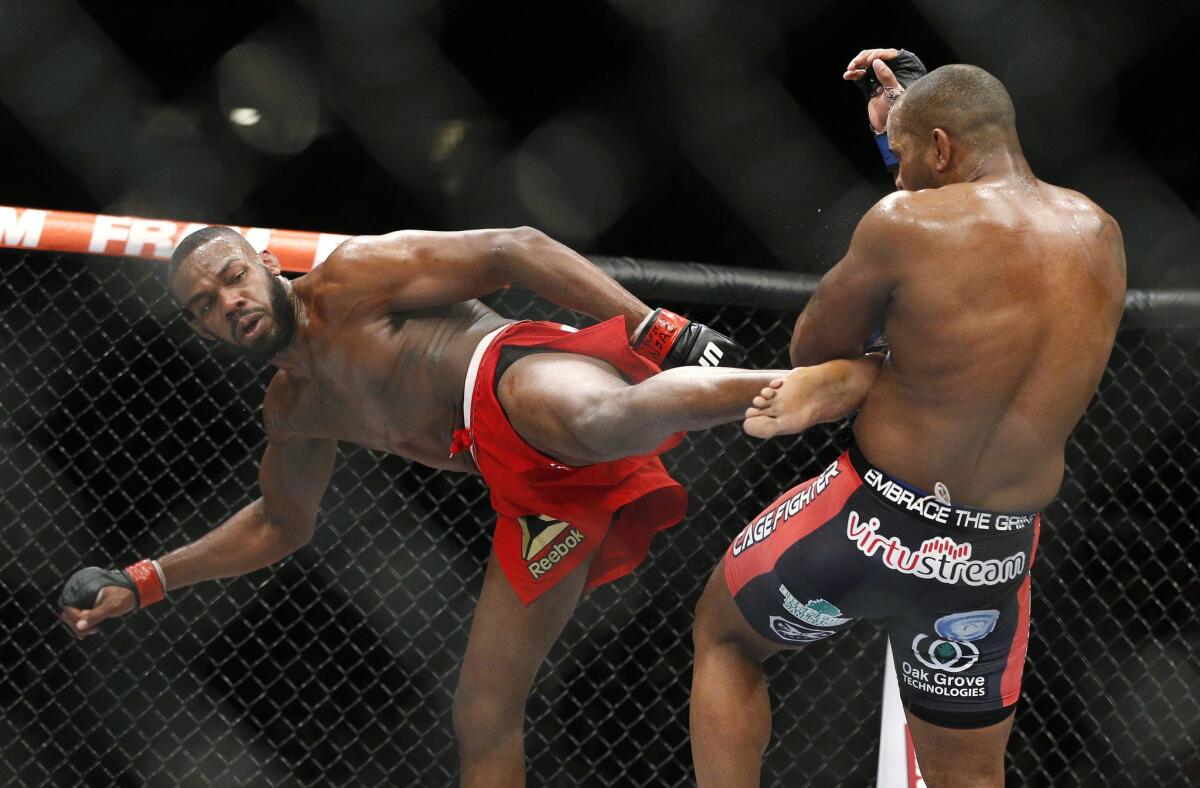 Jon Jones delivers a kick against Daniel Cormier during their UFC 182 light-heavyweight title fight on Saturday night in Las Vegas.