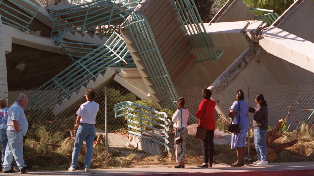 Spectators survey a parking structure at Cal State Northridge in 1994 after the magnitude 6.7 Northridge earthquake.