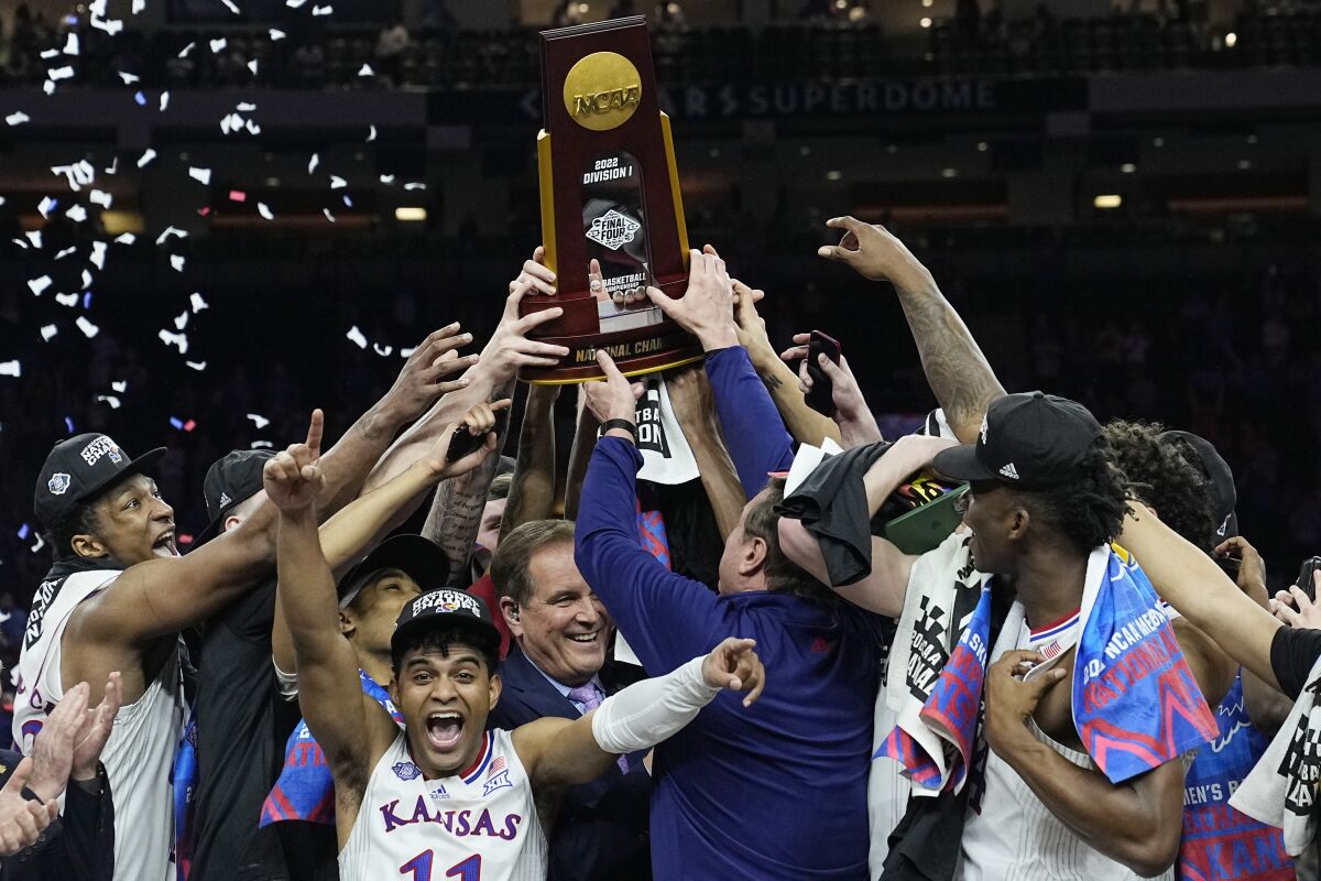 Kansas celebrates with the trophy after their win against North Carolina in a college basketball game at the finals of the Men's Final Four NCAA tournament, Monday, April 4, 2022, in New Orleans. (AP Photo/David J. Phillip)