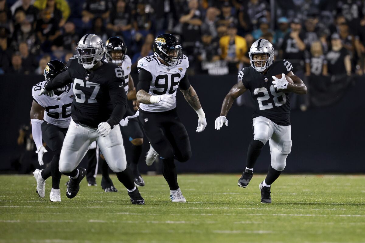 A running back sprints up field in a preseason football game.