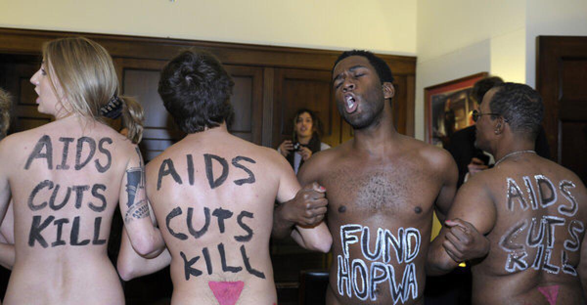 Naked AIDS activists, with slogans painted on their bodies, protest in the lobby of the Capitol Hill office of House Speaker John Boehner.