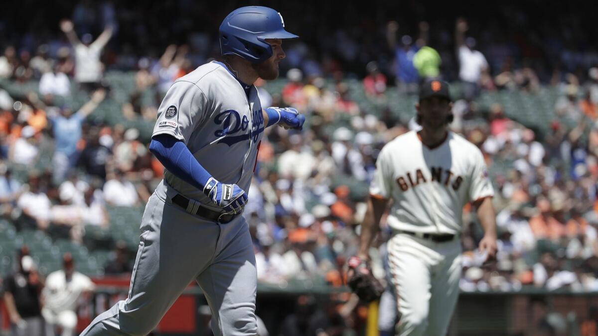 Dodgers first baseman Max Muncy gestures after hitting a home run against San Francisco Giants pitcher Madison Bumgarner, right, during the first inning of the Dodgers' 1-0 victory Sunday.