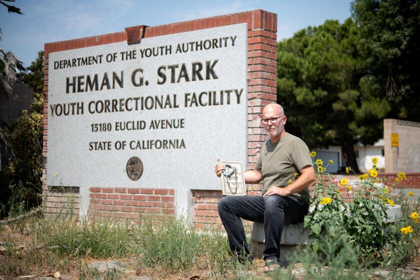 David Reeve holds handcuffs and a logbook outside of Youth Training School on Sunday, Sept. 8.