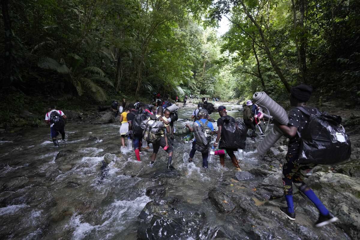 Migrants cross the Acandi River on their journey north, near Acandi, Colombia, Wednesday, Sept. 15, 2021. The migrants, mostly Haitians, are on their way to crossing the Darien Gap from Colombia into Panama dreaming of reaching the U.S. (AP Photo/Fernando Vergara)
