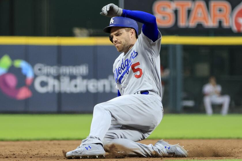 Los Angeles Dodgers' Freddie Freeman hits a three-run triple during a baseball game.