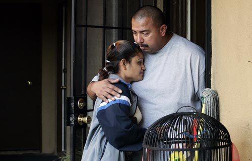 Irma Chavez hugs Samuel Salas, whose daughter, Samantha, was killed outside his apartment complex Saturday. She was shot eight times, and her girlfriend was wounded in the attack, which authorities say had "racial overtones."