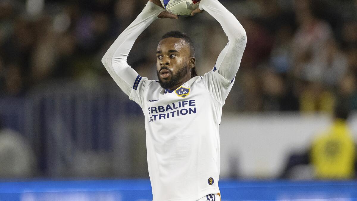 LA Galaxy's Raheem Edwards raises the ball above his head and prepares to throw it in