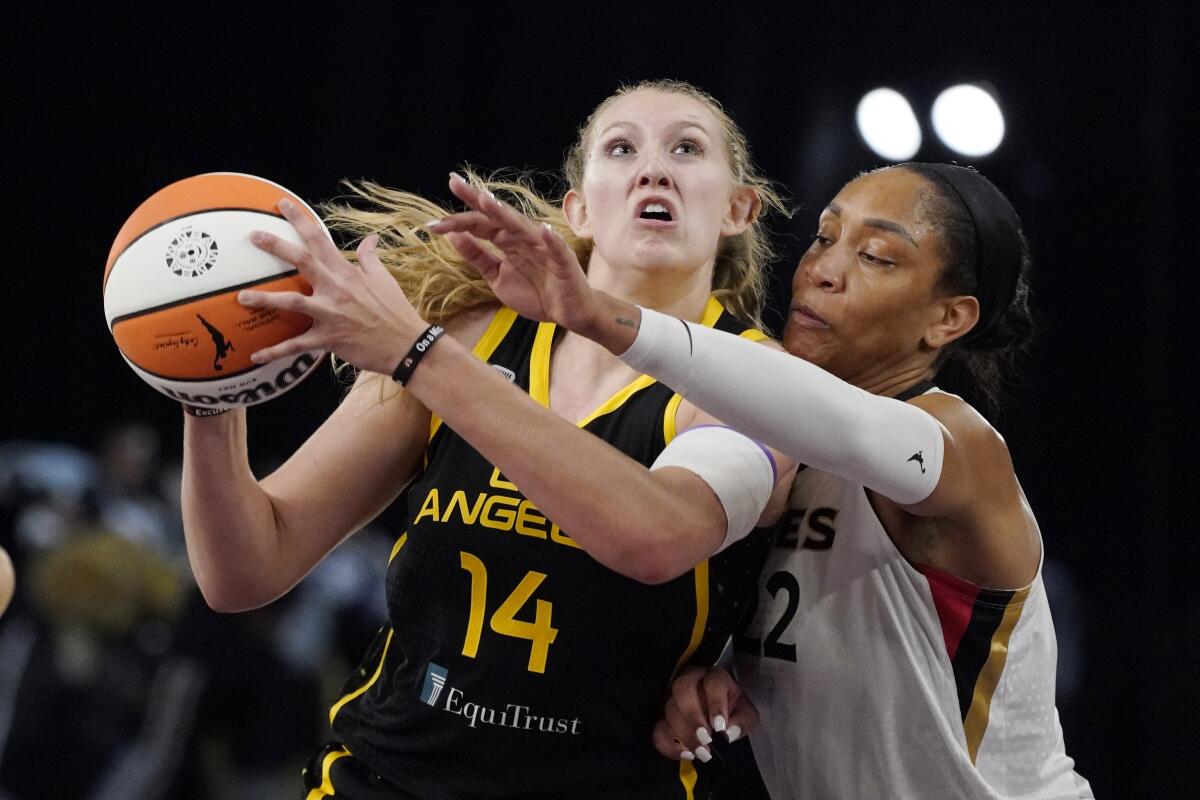 Los Angeles Sparks forward Lauren Cox, left, shoots as Las Vegas Aces forward A'ja Wilson defends 