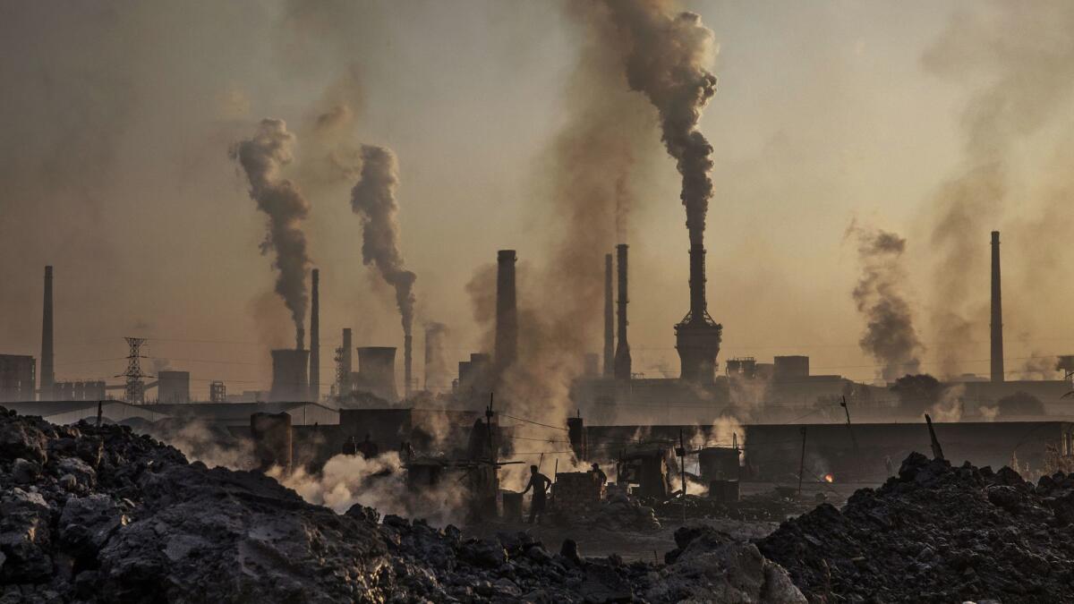 In this November 2016 photo, smoke billows from a large steel plant in Inner Mongolia, China. Chinese authorities are pushing to shut down privately owned steel, coal and other high-polluting factories scattered across rural areas.