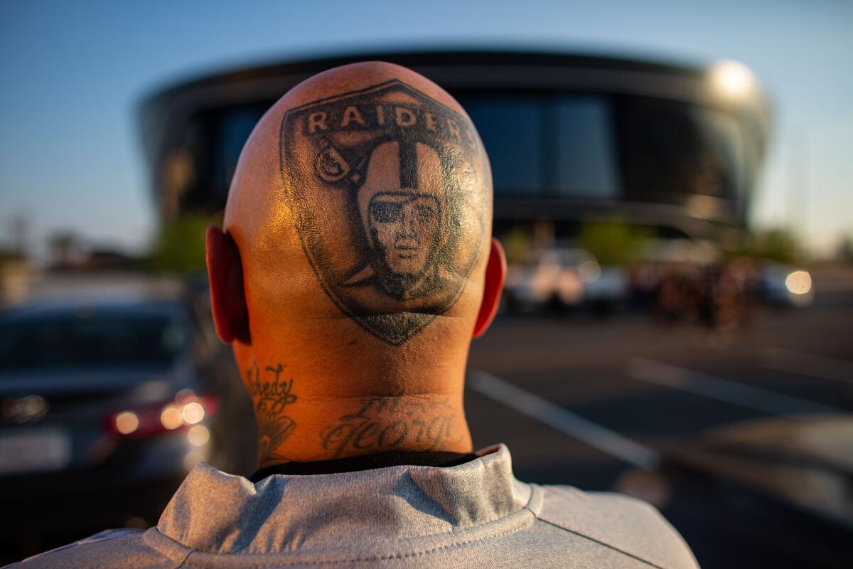Raiders fan with Raiders tattoo on the back of his head.