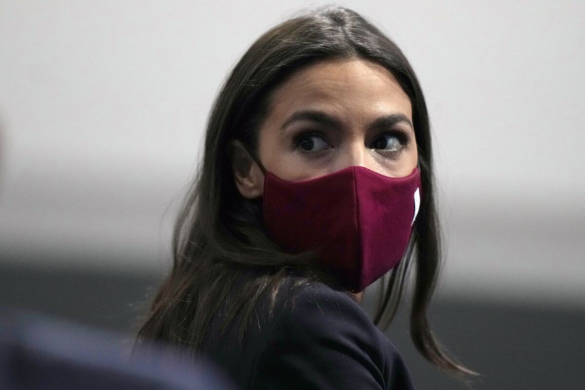 FILE - U.S. Rep. Alexandria Ocasio-Cortez looks round to listen to a question at the COP26 U.N. Climate Summit, in Glasgow, Scotland, Wednesday, Nov. 10, 2021. Ocasio-Cortez has tested positive for COVID-19 and “is experiencing symptoms and recovering at home,” her office said in a statement Sunday, Jan. 9, 2022. (AP Photo/Alastair Grant, File)