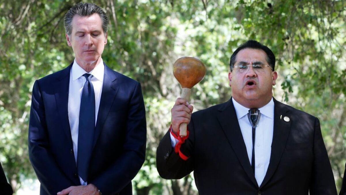 Gov. Gavin Newsom bows his head as Assemblyman James Ramos of the San Manuel Band of Mission Indians opens a meeting with tribal leaders June 18 at the future site of the California Indian Heritage Center in West Sacramento.