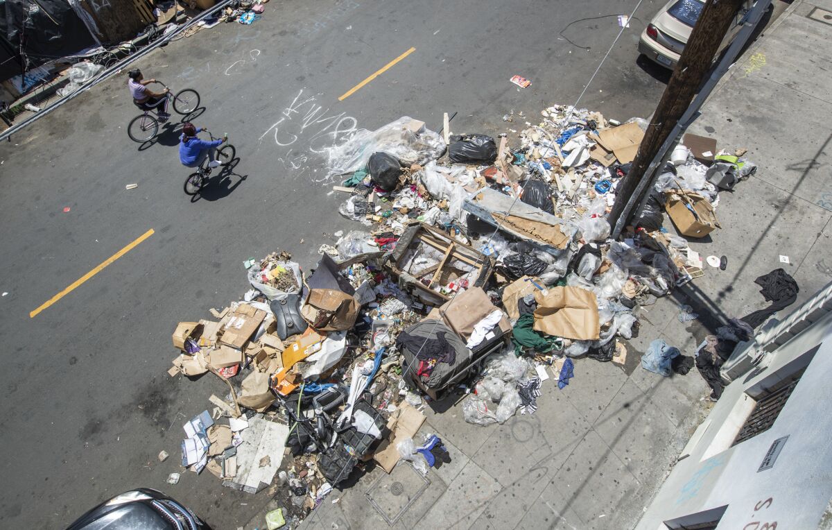Large amounts of trash are piled up on Crocker Street, south of 8th Street, in the skid row section of downtown Los Angeles.