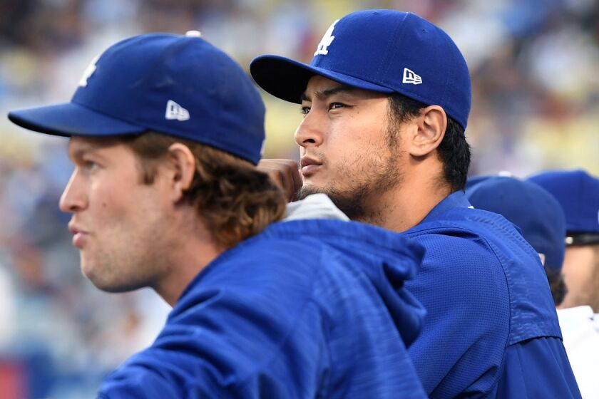 LOS ANGELES, CALIFORNIA AUGUST 15, 2017-Dodgers pitcher Yu Darvish, right, stands next to Clayton Kershaw in the dugout at Dodger Stadium Tuesday. (Wally Skalij/Los Angeles Times)