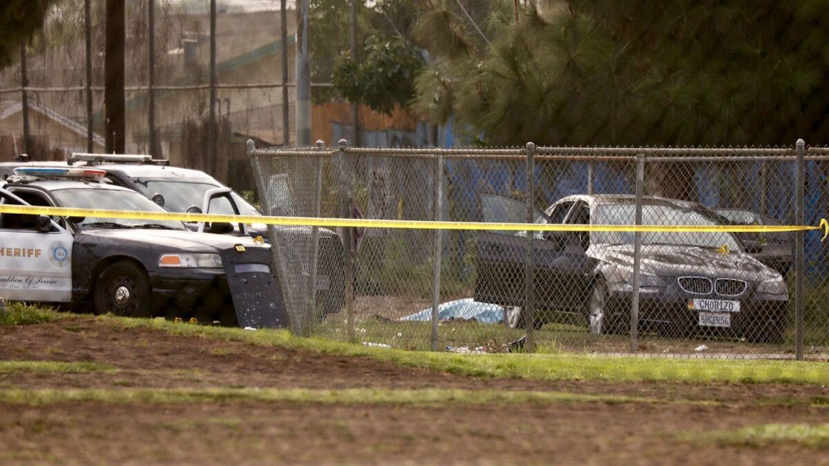 The body of a suspect lies near his vehicle following a deputy involved shooting at Ruben F. Salazar Park in East L.A.