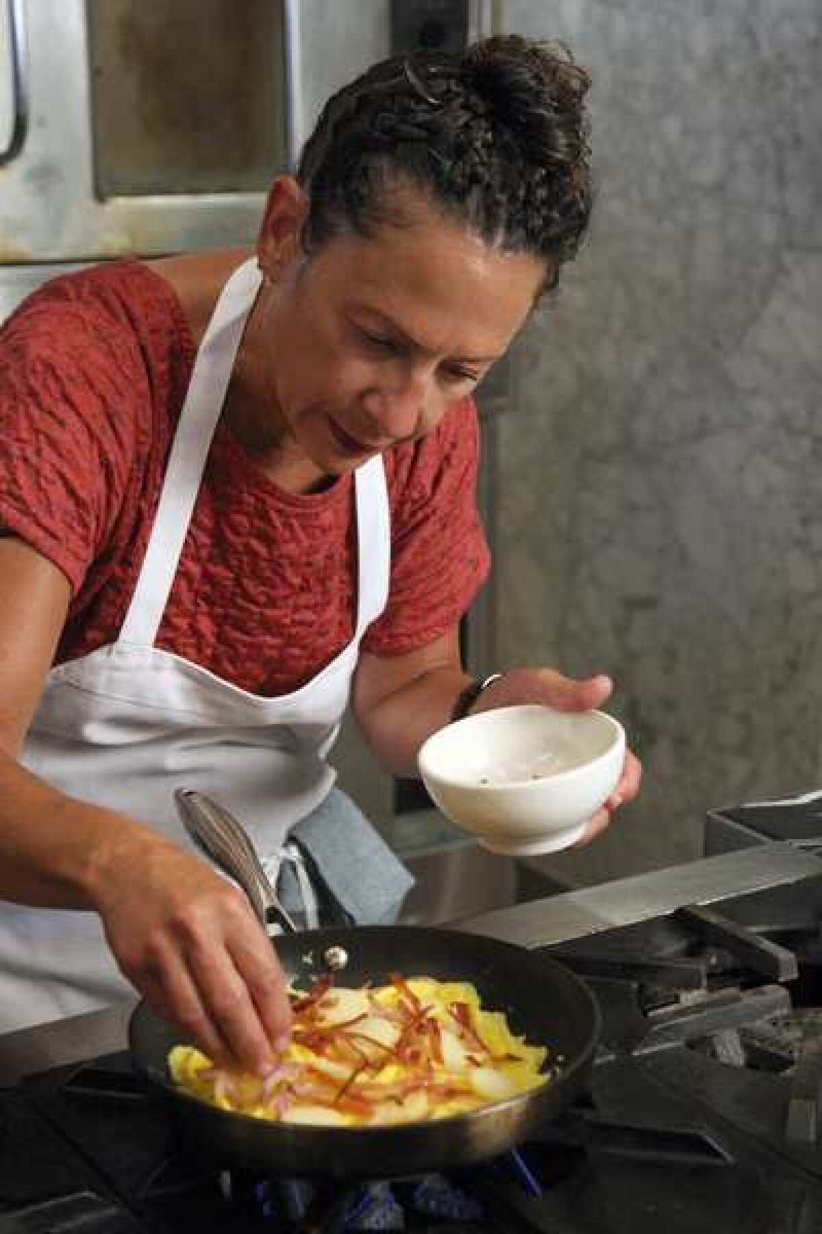 Nancy Silverton, co-owner of Pizzeria Mozza, prepares an Applewood bacon, potato, red onion, chives and aged Gruyere cheese frittata at Scuola Di Pizza in Los Angeles.
