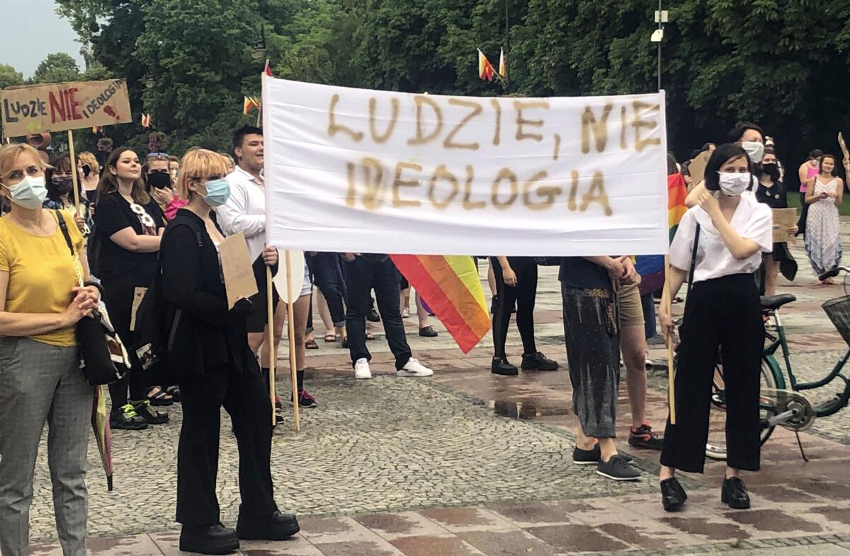 Opponents of Polish President Andrzej Duda display a sign that reads "People, not Ideology," during a protest.