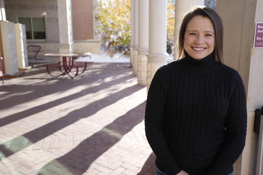 Librarian Brooky Parks is shown outside the library on the campus of the University of Denver on Monday, Oct. 30, 2023, in Denver. Parks, who was fired for standing up for programs on anti-racism and LGBTQ+ stories she organized for teens at the Erie Community Library north of Denver, won a $250,000 settlement in September with the assistance of the Colorado Civil Rights Division. She now works as a librarian at the University of Denver. (AP Photo/David Zalubowski)