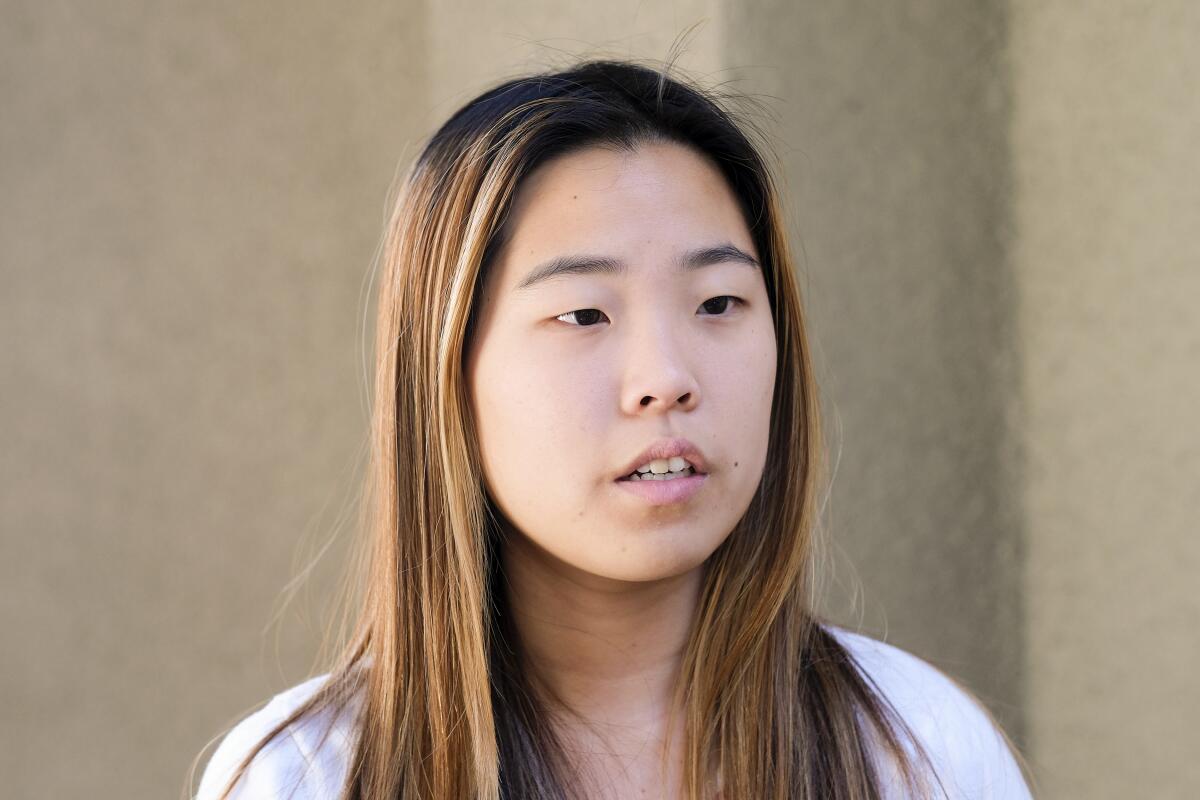 A head-and-shoulders portrait of Christine Kim, a young Asian woman with long hair with highlights, looking off camera.