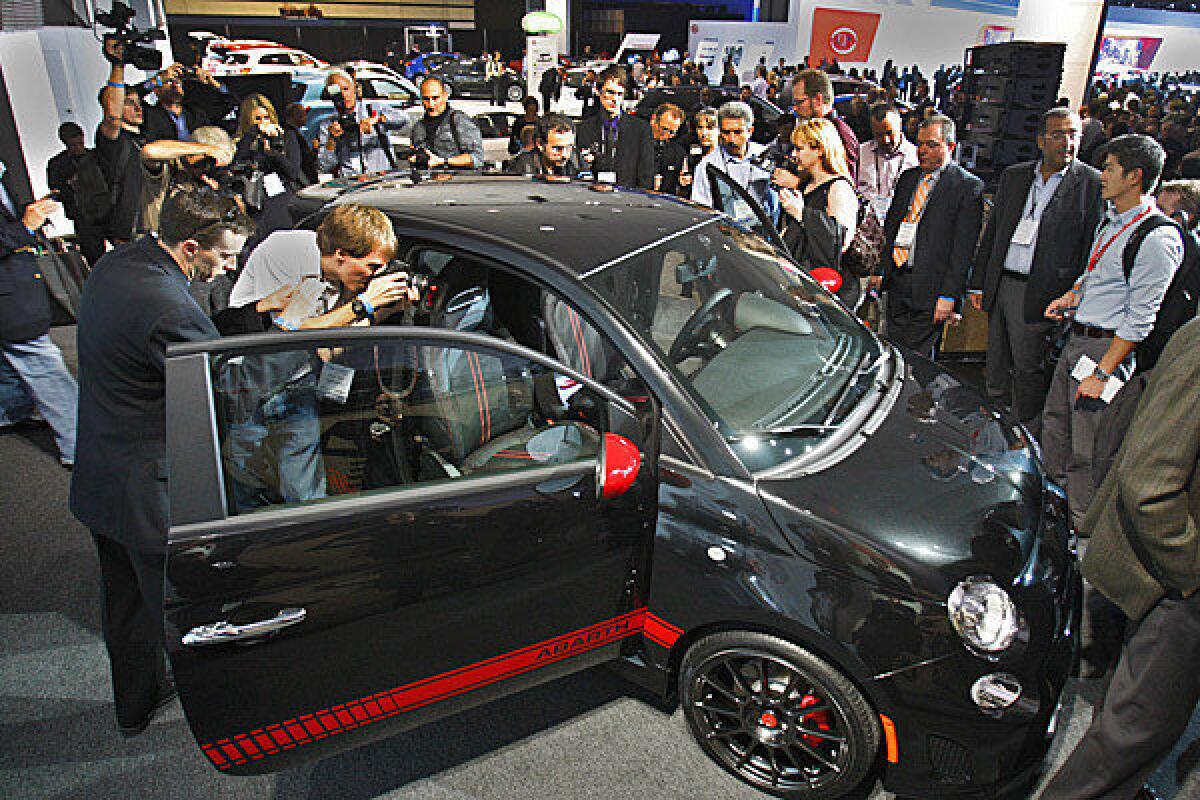 Journalists gather around a Fiat 500 Abarth at the 2011 L.A. Auto Show. The 2012 show opens to the public Friday and runs through Dec. 9.