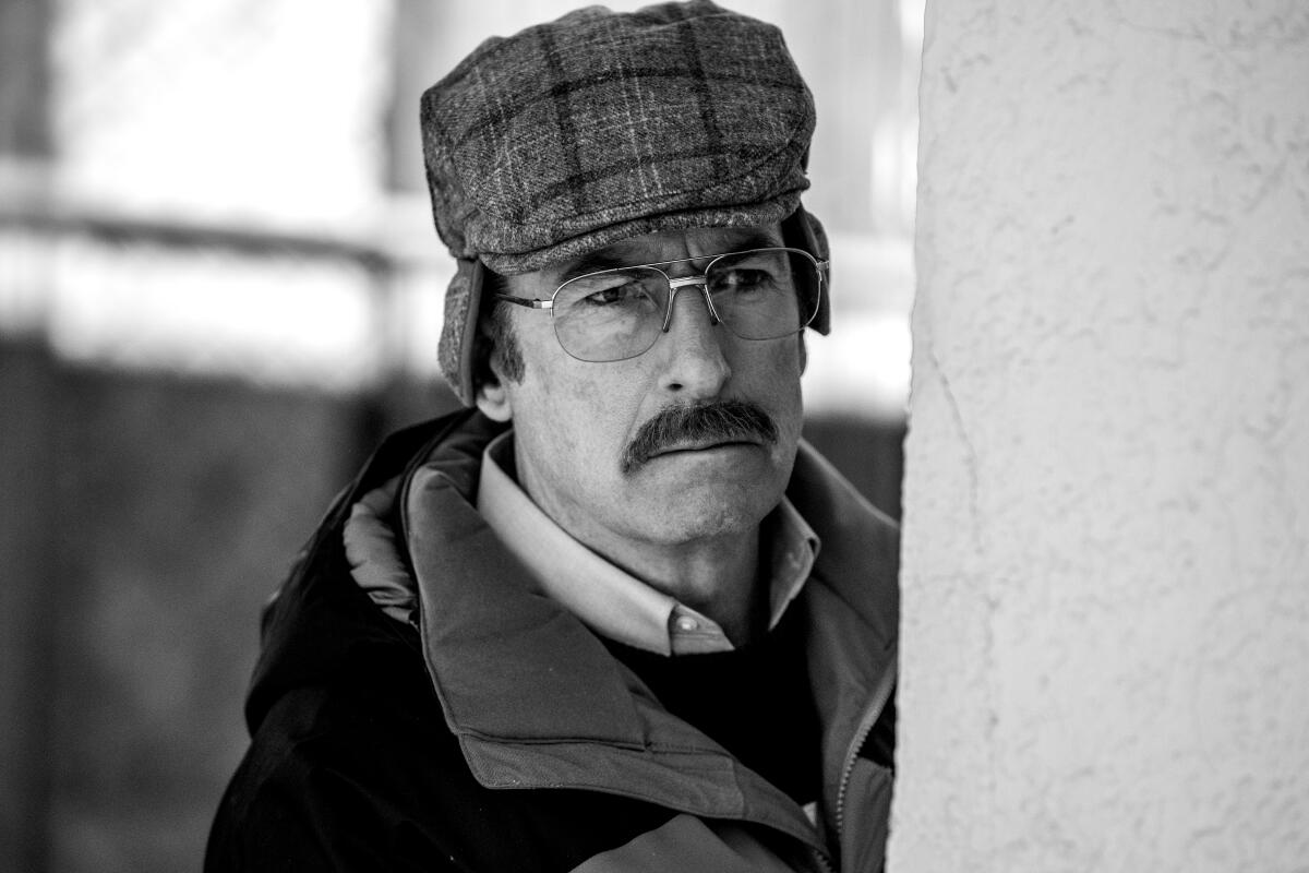 A black-and-white image of a man in winter weather gear.