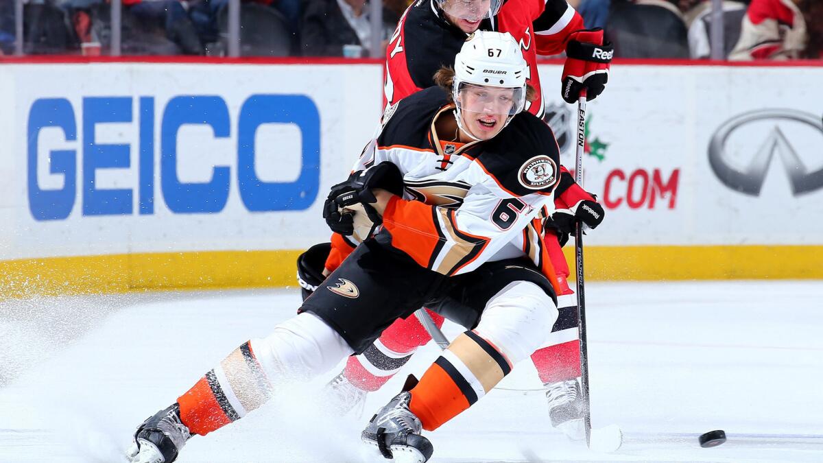 Ducks center Rickard Rakell tries to beat Devils center Tyler Kennedy to the puck during their game Saturday.